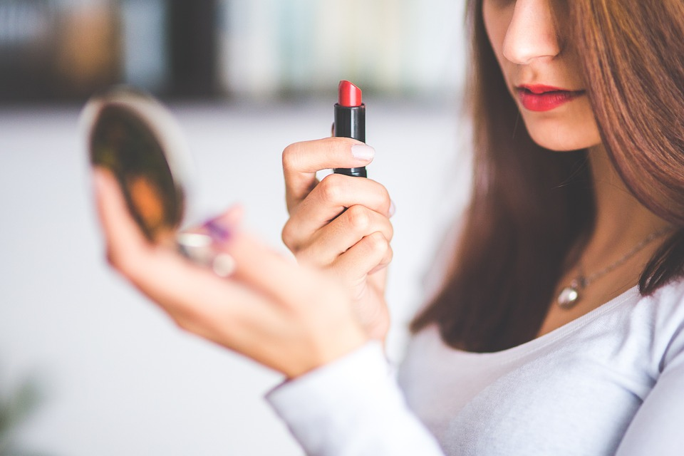 Woman retouching lipstick