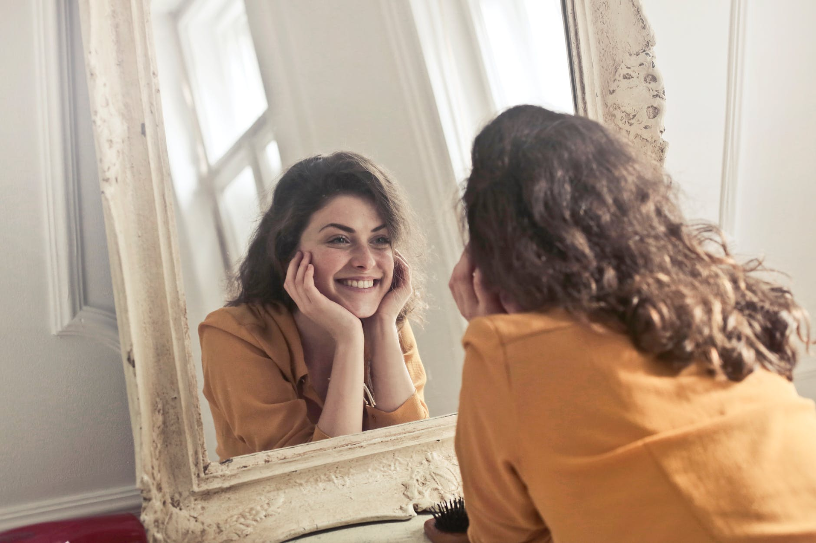 Brunette woman smiling in the mirror. 